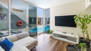 Una sala moderna con un sofá, un televisor y una planta en maceta.