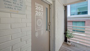 Entrada d'hotel amb un senyal que indica l'accés al segon pis cap a Suïts 203-207, bugaderia per a clients i gimnàs/zona de lobby.