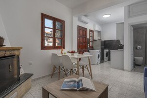 Une cuisine compacte comprenant un coin repas, un lave-linge encastré et une petite table à manger avec des chaises.