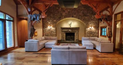 Vaulted beam ceilings, a huge rock fireplace, stream nearby, large campfire area