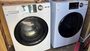 Two front-loading washing machines in a laundry area with a broom and a mop. - Cozy studio walking distance to the beach, Seas the Day Beach House (Cameron)