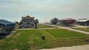 A residential area with a large house featuring a porch and a smaller building nearby. - Cozy studio walking distance to the beach, Seas the Day Beach House (Cameron)