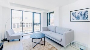 A modern living room with a sofa, armchair, and a coffee table. - Impeccable 1-bed Apartment in London (London)