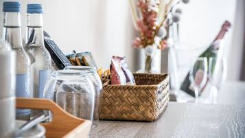 Une table avec des bouteilles en verre, un panier en osier et un verre.