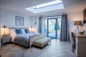 A bedroom with a skylight, a bed with pillows, a bench, a desk, and a chair. - The Sleeping Giant - Pen Y Cae Inn (Swansea)
