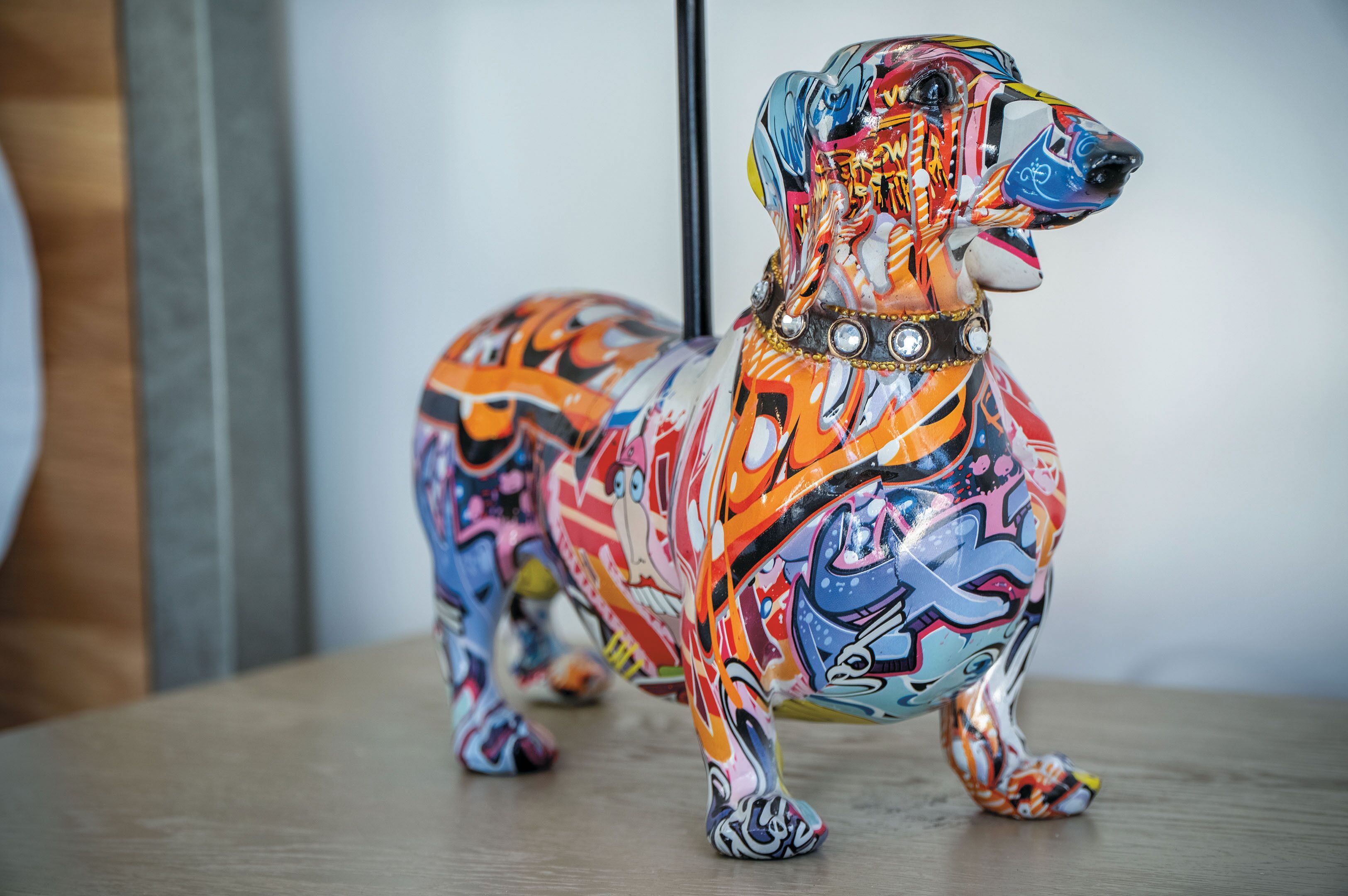 Una escultura colorida de un perro, en estilo graffiti.