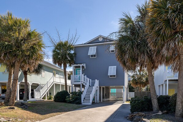 A two-story building with a balcony, a staircase, and a gated entrance. - Palm's Paradise, Oceanview Home located in Atlantic Beach, NC! (Atlantic Beach)