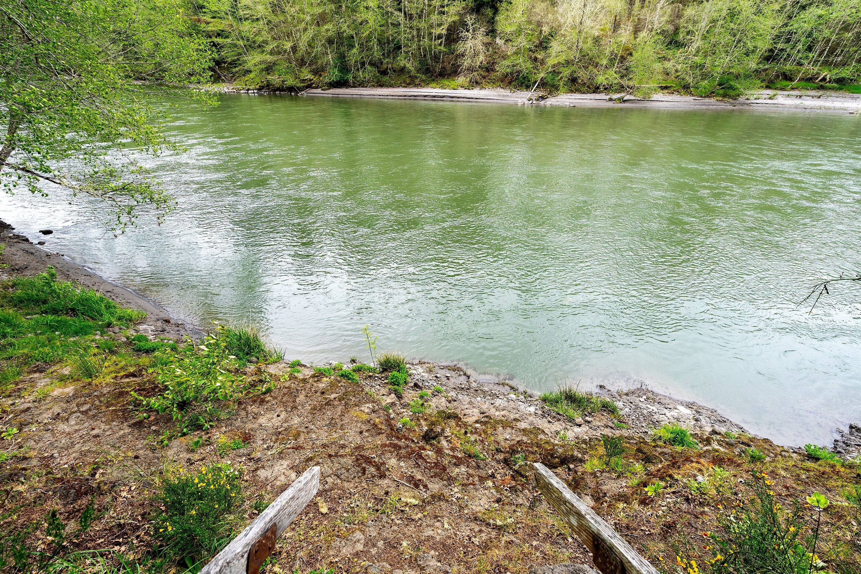 A river with a wooden walkway along the bank.