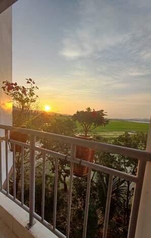 A balcony with a view of a sunset over a green landscape. - LAK VIEW (Lak)