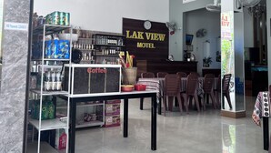 Eine Hotelhalle mit einer Kaffeestation, einem Empfangstresen und einem Schild mit der Aufschrift 'LAK VIEW HOTEL'.