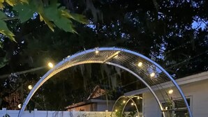 Une terrasse extérieure dotée d’un espace salon circulaire, d’une petite table et d’un foyer.