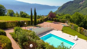 A swimming pool with a view of a lake and mountains. - Lake view over Lake Garda, pool, 90× 5‑star reviews, ideal for cycling, hiking (Tignale)