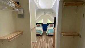 A narrow hallway with wooden flooring leading to a room with two beds, a ceiling fan, and skylights. -  Weeki Wachee river !! REAL FLORIDA! Read OUR  5 STAR REVIEWS (Spring Hill)