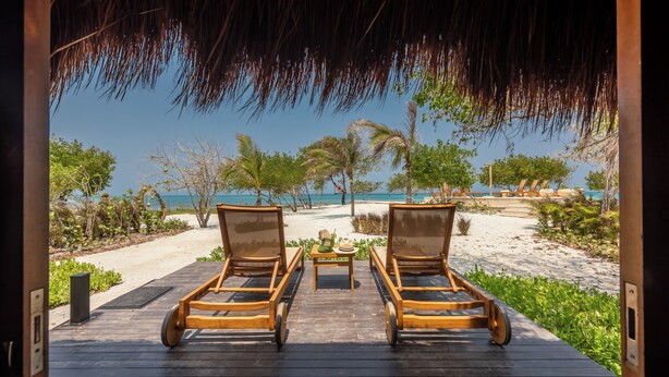 A wooden deck with two lounge chairs facing a beach. - ACASI Rustic Beach (Cartagena)