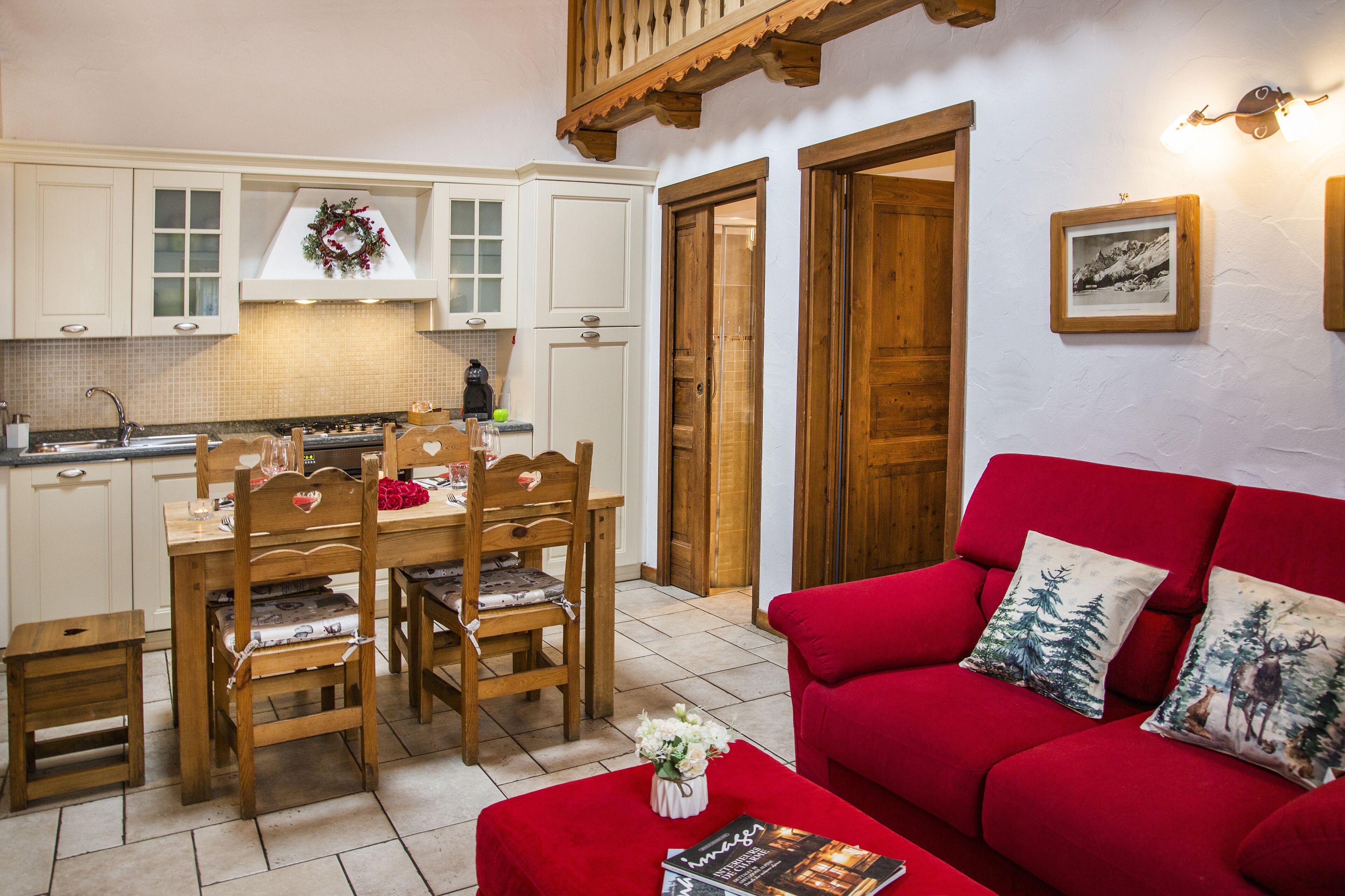 A cozy living room with a red sofa and a dining area with wooden furniture.