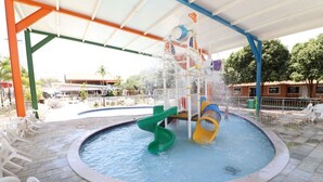 A water play area with slides and a pool, surrounded by a covered seating area with chairs. - diRoma Fiori - Com 1 dia no Acqua Park (Caldas Novas)