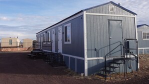 A single-story mobile home with a front porch and a small attached garage. - 068C Cozy Studio Grand Canyon South Rim Sleeps-2 (Williams)