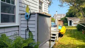 A house with a covered porch, a birdhouse, and a fenced yard.