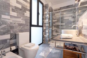Une salle de bain moderne avec une douche à parois de verre, des toilettes et un lavabo avec une serviette.