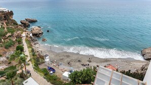 A coastal view with a beach, rocky cliffs, and a clear sky. - Casa Carpa Andalucia IV Carabeo Playa (Nerja)