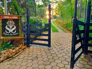 A gated entrance with a sign reading "Sopro da Serra Chalés."