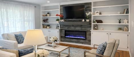 Smart TV, chimenea, libros y biblioteca musical