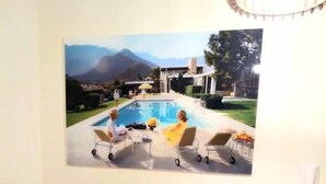 A dining area with a table set for four, a painting of a pool and mountains, and a phone on the wall. - Fionia In Gazi- Athens Center Apartment Free Wifi (Athens)