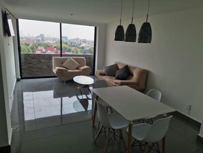 Enjoy a city view from the comfort of this stylish living space with a sliding glass door leading to an outdoor area.
