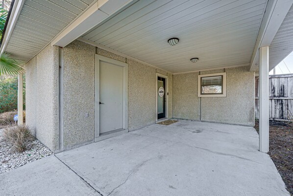 A covered patio area with a concrete floor, a door, and a window. - Northeast Wilmington Home ~ 5 Mi to Beach! (Wilmington)