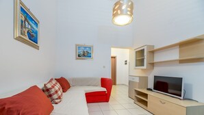 A modern living room with a sofa, red armchairs, a TV, and a painting on the wall. - Modern accommodation just 450 metres from the sea (Baska)