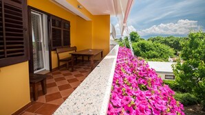 A balcony with a checkered floor, a wooden bench, and a table. - Large flat with 3 air conditioning units, WiFi, BBQ, car park (Baska)