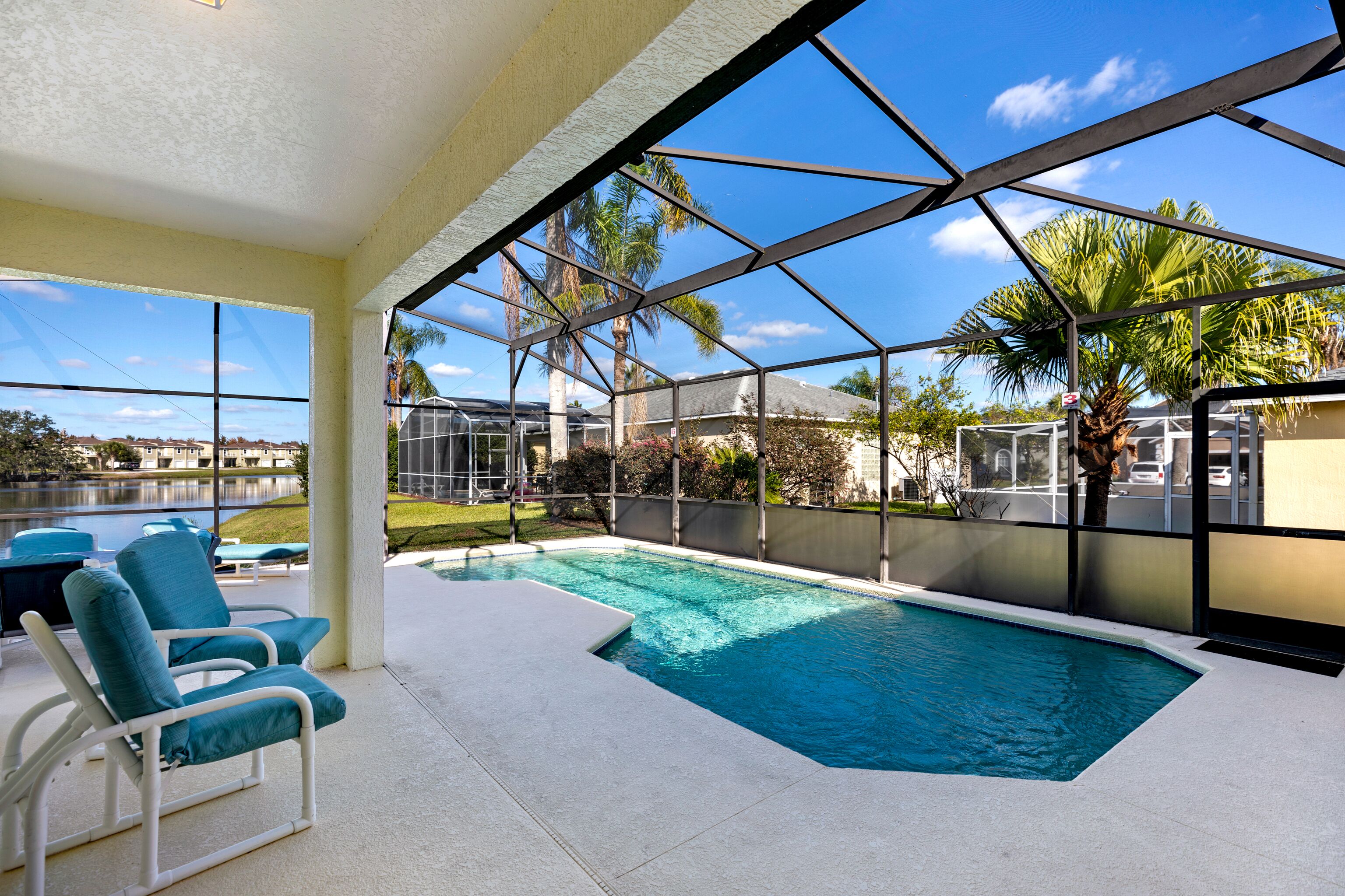 A pool area with clear views of palm trees and a distant building.