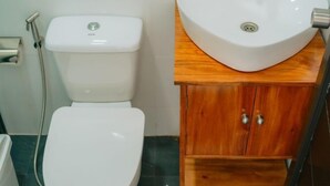 A bathroom with a toilet, a sink, and a mirror.
