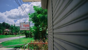 Cartel de una posada con vistas a un paisaje verde y cielo despejado.