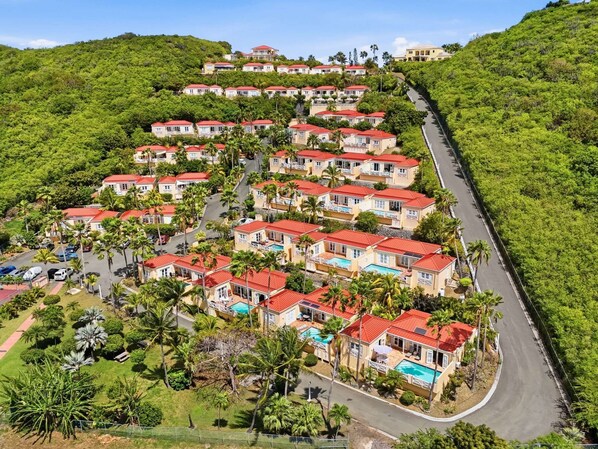 A residential area with houses on a hillside, a winding road, and a clear sky. - Seaview Palms at Villa Madeleine – Private Pool – East End St. Croix (Christiansted)