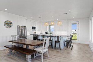 Enjoy meals in the kitchen with stainless steel appliances and a dining area with a wooden table.
