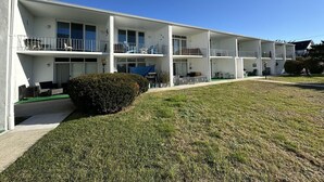 Ein mehrstöckiges Motel mit Balkonen, einem gepflegten Rasen und blauem Himmel.