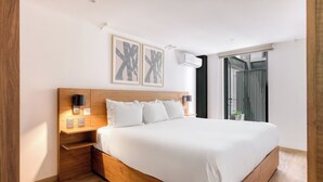 Una camera da letto moderna con un letto grande, una testiera in legno, comodini, luci a parete e una finestra con tende.