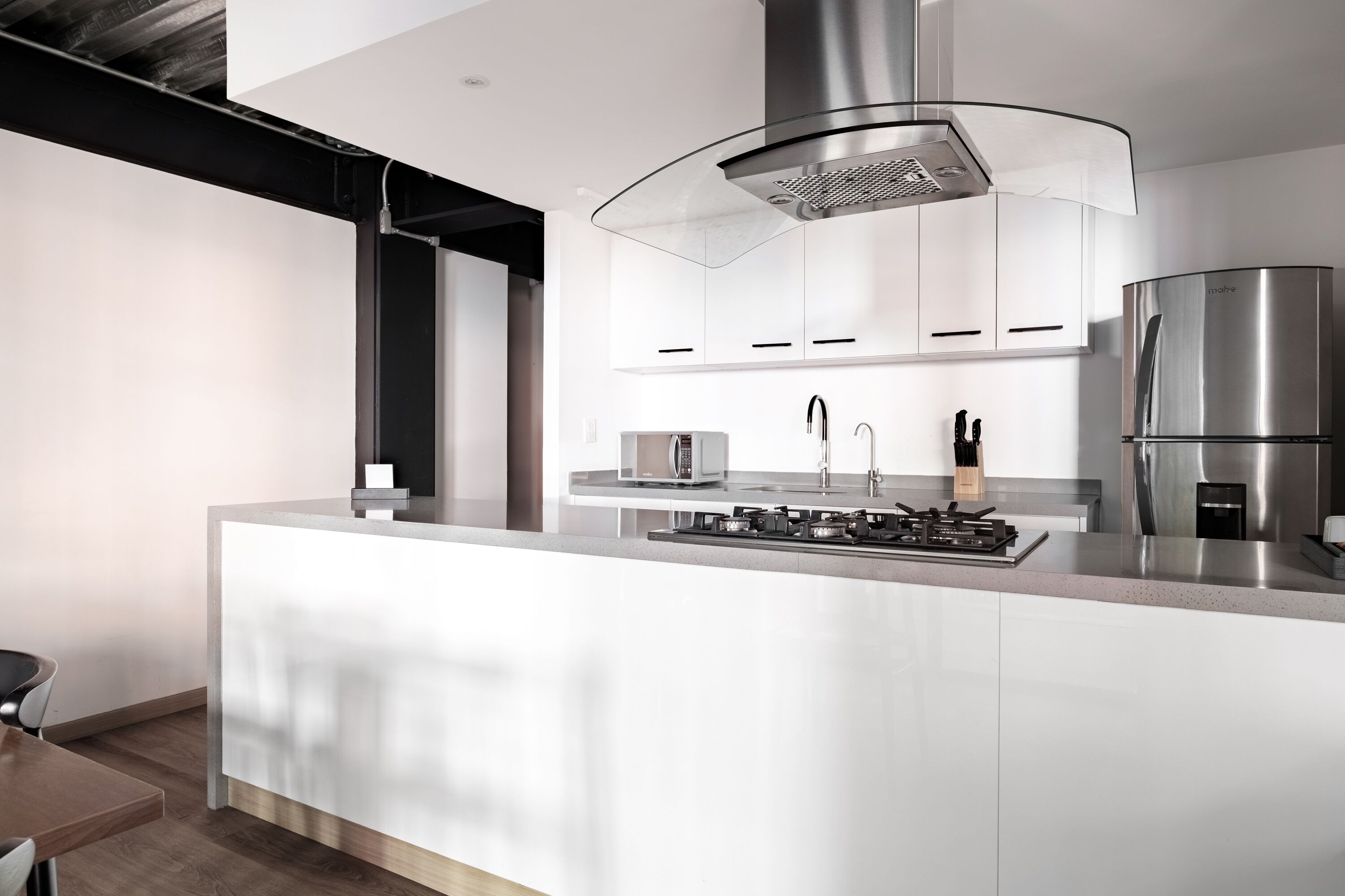 Una cocina moderna con una isla central, electrodomésticos de acero inoxidable y un diseño elegante.
