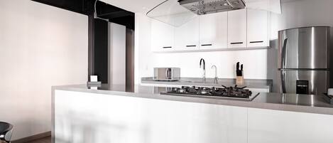 Una cocina moderna con una isla central, electrodomésticos de acero inoxidable y un diseño elegante.