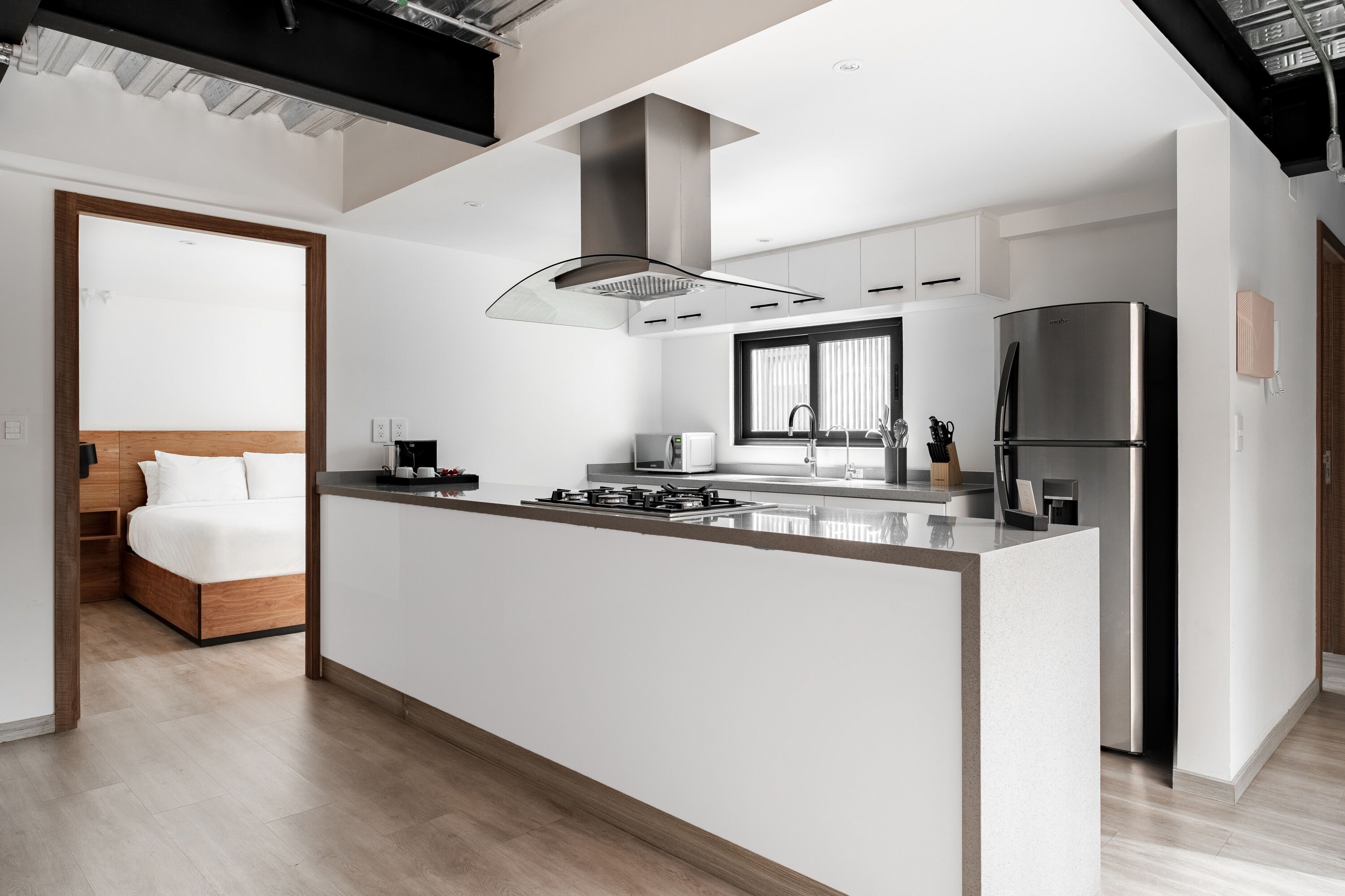 Una cocina moderna con una isla central, electrodomésticos de acero inoxidable y una estufa empotrada.