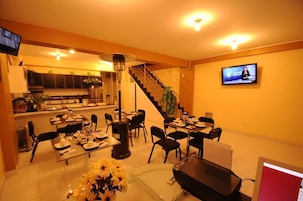 Uma cozinha moderna com área de jantar, escada e televisão na parede.