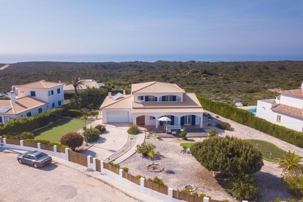 A coastal villa with a spacious driveway, a swimming pool, and a view of the sea. - Vila OceanBreeze Aljezur 4 Bdrms10 Px Heated Pool Spacious & Cozy, Sea & Nature (Aljezur)