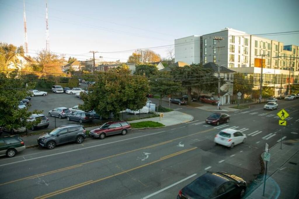 A multi-story building with a parking lot in front.