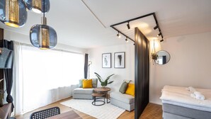 Una sala de estar moderna con un conjunto de sofá, una mesa de comedor y un televisor.
