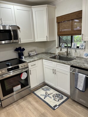 Enjoy cooking in this well-lit kitchen with a sink, microwave, oven, and dishwasher.