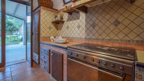 A kitchen with a stove, cabinets, and a tiled backsplash.