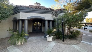 A building with a classical architectural style, featuring a central entrance with a pediment supported by columns, and a tiled roof. - Well Located Condo in Scottsdale near TPC Golf 2BR 2BA (Scottsdale)