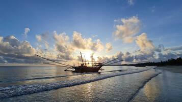 A boat on a calm sea with a clear sky and clouds.