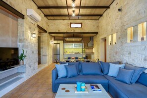 A cozy living area with a stone wall, a blue sofa, and a coffee table.